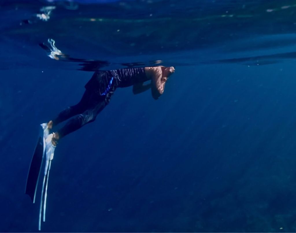 A photo of Froyows Travel & Freediving's founder floating on the water surface preparing for his dive
