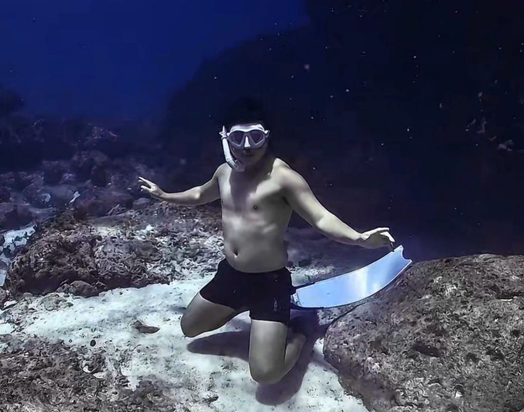 Froyows partner kneeling underwater with a fierce yet relaxed pose during a safety-focused freediving session in Siquijor
